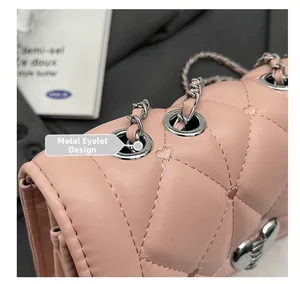 Détail du sac en cuir rose matelassé avec surpiqûres en cœur et chaîne en métal argenté