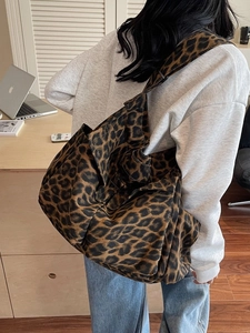 Large leopard print canvas tote bag for women shown as cross body on a model