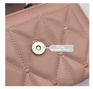 Détail du sac matelassé rose montrant la broderie cœur et le fermoir magnétique puissant