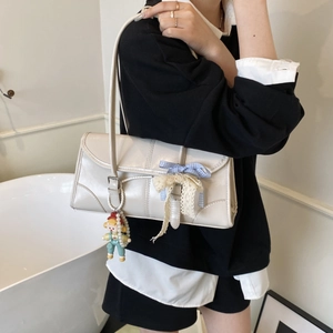 Chic beige tote bag with light blue bow and lace details featuring a cute doll pendant