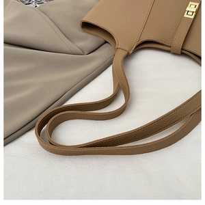 Detail of lychee pattern leather and gold twist lock on the khaki tote bag