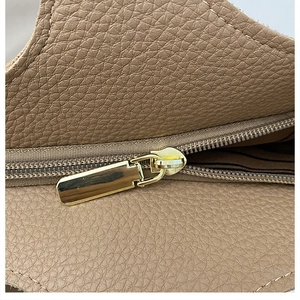 Close-up of premium tan lychee pattern leather and high-quality gold zipper detail