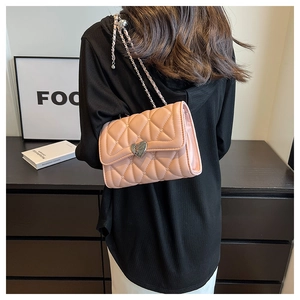 Vue détaillée du dos du sac matelassé rose avec fermoir en cœur et bandoulière chaîne