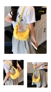 Detail of a bright yellow dumpling bag with knotted strap and heart charm on a model