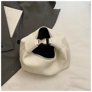 Détail du sac à main blanc plissé avec boucle en métal argenté sur une veste grise