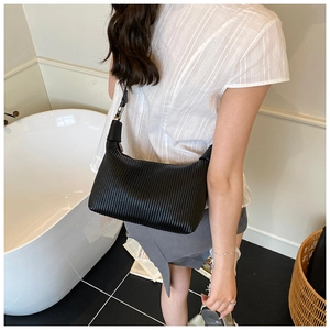 Détail d'un sac à bandoulière plissé noir avec boucle argentée réglable porté