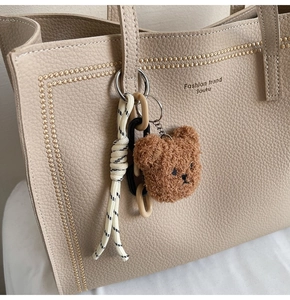 Brown fluffy teddy bear pendant charm on beige tote bag with chic rope keychain