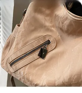 Detailed macro view of the marble-textured faux leather tote with a metal zipper pocket