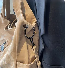 Close-up of vintage wrinkled leather tote with dark metallic ring hardware and strap