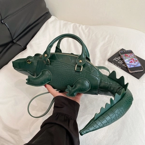 Dettaglio di una borsa creativa a forma di coccodrillo verde scuro in finta pelle goffrata