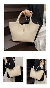 Detailed view of cream leather tote bag featuring lychee texture and gold metal buckle