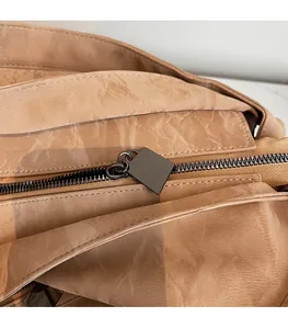 Macro shot of durable gunmetal zipper and textured tan leather tote bag detail