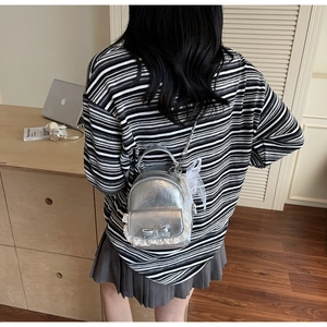 Silver pleated mini backpack with lace and bow detailing shown on a model