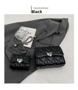 Vue détaillée de sacs matelassés noirs avec boucles cœur argentées sur costume gris
