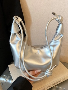 Metallic silver crescent shoulder bag with knotted strap and minimalist logo on leather