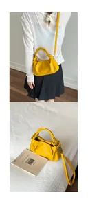Detail of a bright yellow pleated leather handbag with a knotted handle and silver buckles