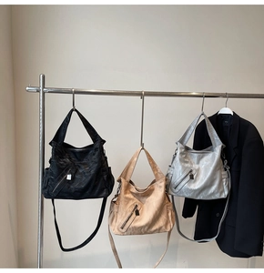 Three large tote bags in black, brown, and silver with textured leather and front zippers