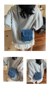 Detail of blue denim crossbody bag featuring a metal snap closure and vintage style