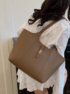 Brown large capacity leather tote bag with gold swivel lock and adjustable shoulder strap