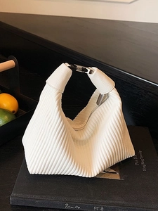 Sac à main en tricot plissé blanc avec fermoir argenté dans un style minimaliste