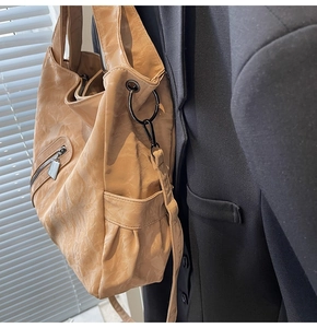 Detail of camel PU leather tote with retro wrinkled texture and metal ring buckle side view