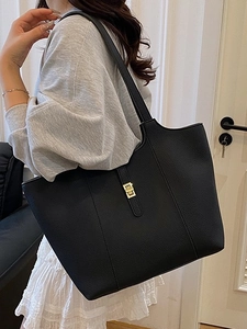 Minimalist black lychee texture tote bag with gold buckle shown on a female model