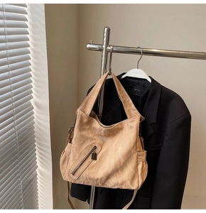Detail of minimalist beige tote bag with pleated texture and functional side pockets
