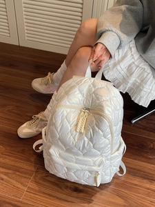 Chic white quilted puffer backpack for women featuring heart-shaped stitching and side pockets