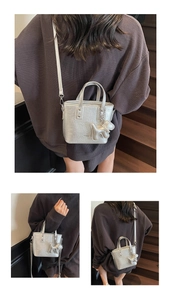 Detail of silver metallic mini bucket bag with puppy charm and detachable shoulder strap