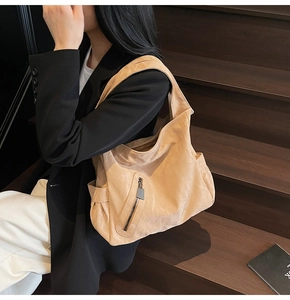 Detail of the large beige hobo bag with soft pleated leather and side metal zipper pocket