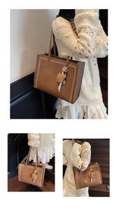 Close-up of brown pebbled leather tote bag with contrast stitching and bear charm