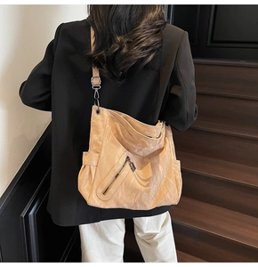 Model back view showing the apricot pleated tote bag with silver buckle and side pocket