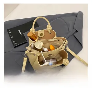 Vista interna del bolso cubo de cuero litchi con tres compartimentos y asa con nudo