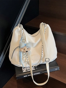 Sac hobo crème à texture cuir avec charmant pendentif ours en peluche sur livre