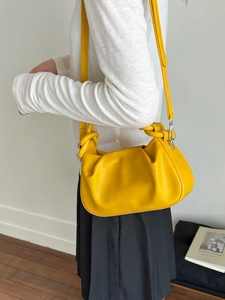 Chic yellow leather crossbody bag with unique knot handle design and removable strap