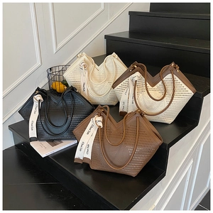 Detailed display of hollowed-out tote bags in four colors with decorative silk scarves
