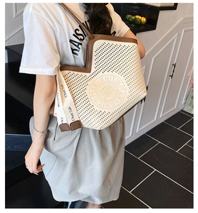 Detail of laser-cut perforated tote bag with logo and decorative brand letter strap