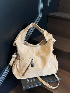 Minimalist beige textured tote bag with multi-pockets and adjustable shoulder strap