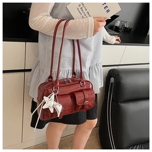 Detail of burgundy patent leather bag with silver hardware and decorative star charms