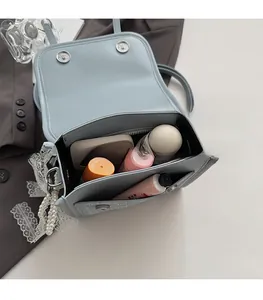 Internal view of light blue PU leather handbag showing large capacity and pearl strap