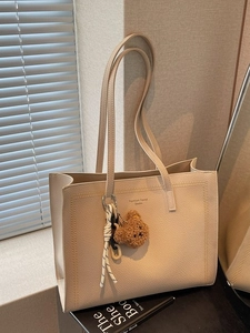 Minimalist cream tote bag in lychee leather with fashion trend text and bear pendant