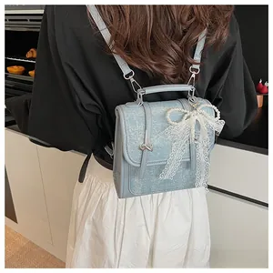 Close-up of glitter blue backpack with lace bow, pearl chain and star metal hardware