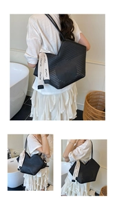 Detail view of black laser-cut tote bag with V-shaped top and branded strap