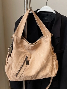 Minimalist beige tote bag with pleated texture and adjustable straps for urban commute