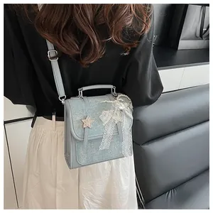 Light blue glitter handbag featuring star appliqués and a pearl butterfly charm detail