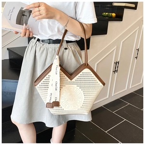 Detail of laser-cut tote bag with brown trim and stylish patterned silk ribbon
