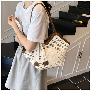 Close-up of laser-cut perforated pattern and embossed logo on two-tone tote bag
