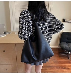 Minimalistische schwarze Totebag mit Litschi-Struktur an der Schulter im Büro-Look