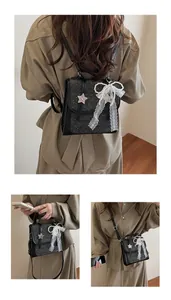 Detail of black glitter backpack showing bow lace and pearl chain accessories