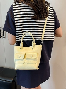 Pale yellow crocodile embossed bucket bag with knot handle and dual front pockets